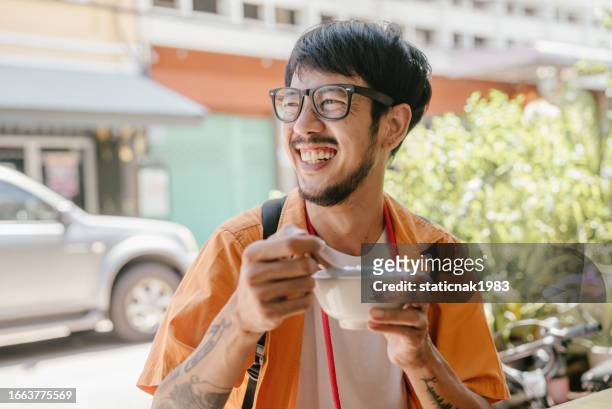asian man chewing and enjoy tasty thai dessert in restaurant at bangkok city. - tasty stock pictures, royalty-free photos & images