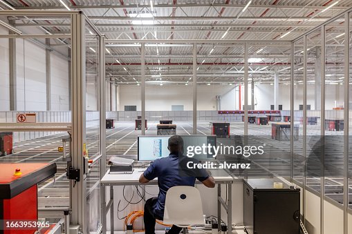 Man operating parcel sorting robot system in warehouse Man operating parcel sorting robot system in warehouse