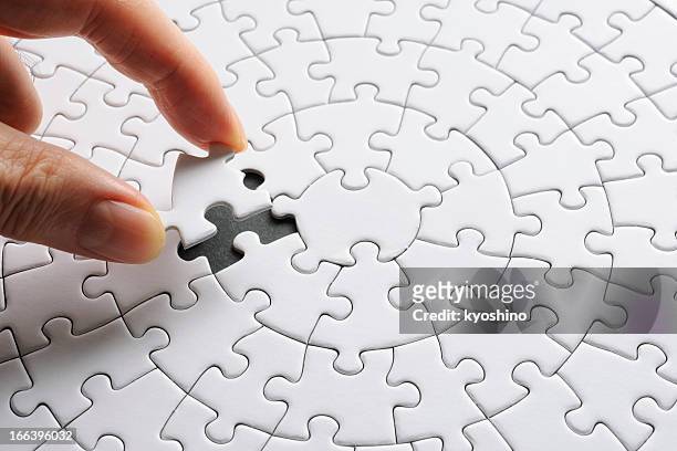 hält eine weiße leere letztes puzzleteil - jigsaw puzzle stock-fotos und bilder