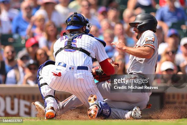 Paul DeJong of the San Francisco Giants is tagged out a home by Miguel Amaya of the Chicago Cubs during the third inning at Wrigley Field on...