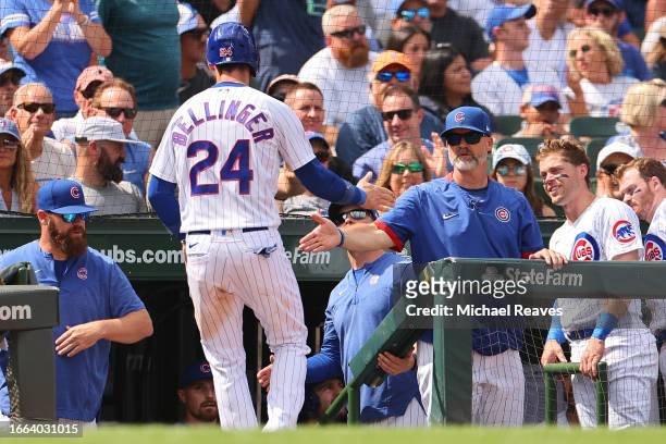 Cody Bellinger of the Chicago Cubs high fives manager David Ross after scoring a run during the third inning against the San Francisco Giants at...