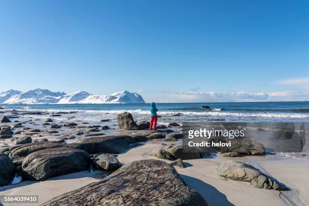women in winter jacket on uttakleiv beach, lofoten - winter coat stock pictures, royalty-free photos & images
