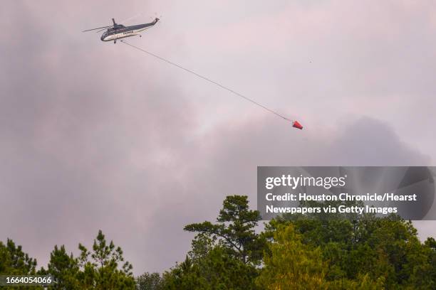 Firefighting helicopter flies over a wildfire in rural Walker County, that has spread up to 3,800 acres, on Saturday, Sept. 2, 2023 north of...