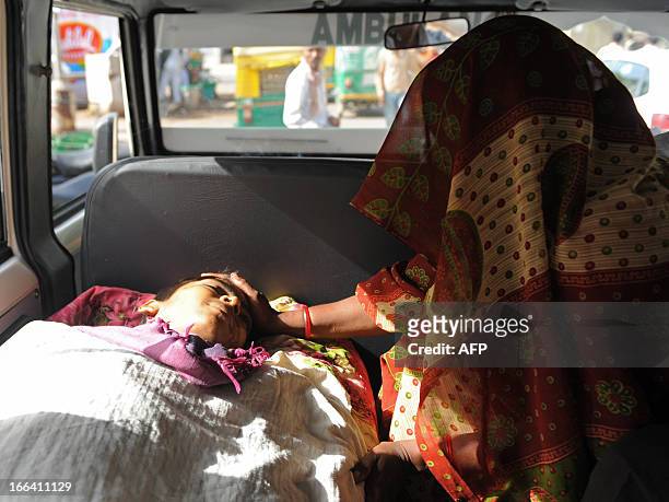 The body of Rajubhai Ambubhai Bodana who succumbed to blood cancer, is pictured in a van as his aunt mourns outside the Gujarat Cancer and Research...