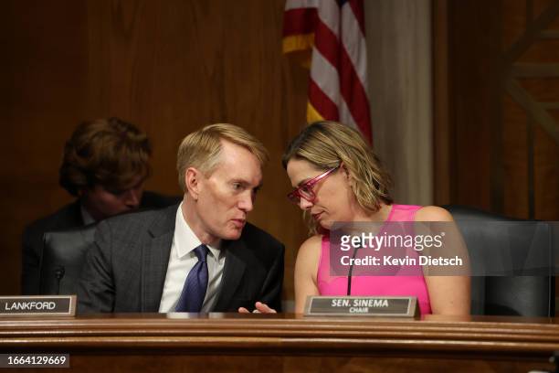 Sen. James Lankford talks to Sen. Kyrsten Sinema talk during a Senate Homeland Security and Government Affairs subcommittee hearing on Title 42, at...