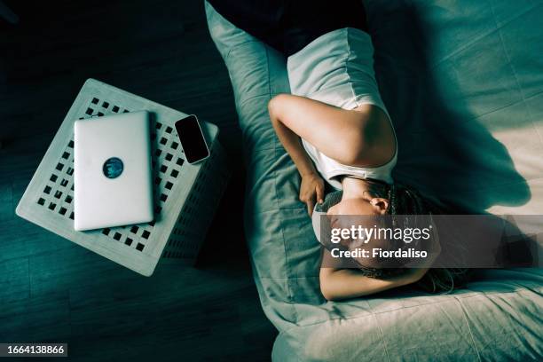 portrait of a woman lying on the sofa - krankenstand stock-fotos und bilder