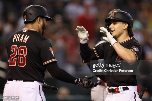 Alek Thomas of the Arizona Diamondbacks high fives Tommy Pham after hitting a three-run home run against the Colorado Rockies during the thid inning...