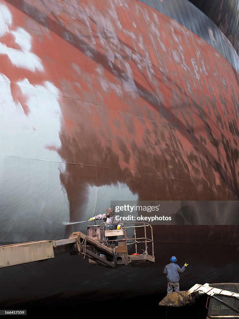 Shipyard worker paint the ship