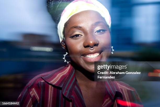 portrait with motion of a cheerful young african woman outdoors - charming stockfoto's en -beelden