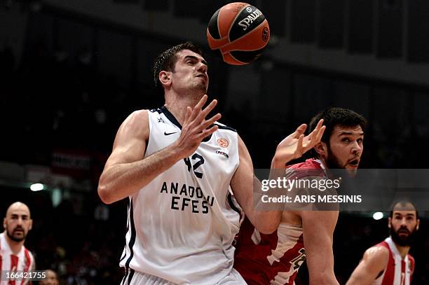 Stanko Barac of Anadolu Efes vies with Kostas Papanikolaou of Olympiakos during their Euroleague playoff basketball match in Athens on April 12,...