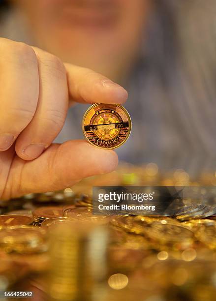 Mike Caldwell, of Casascius, displays a Bitcoin that was just made for a photograph in Sandy, Utah, U.S., on Friday, April 12, 2013. Created four...