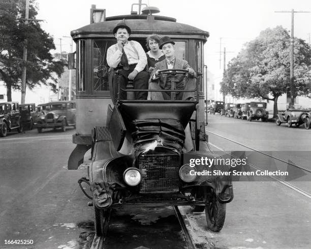 Comedians Oliver Hardy and Stan Laurel in their Model T Ford after it has been crushed by two trolley cars in a scene from the French language...