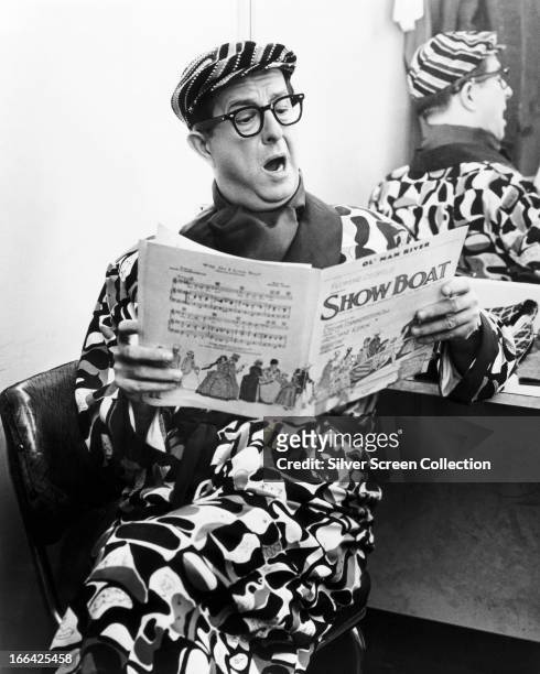 American comedian Phil Silvers singing from the sheet music to 'Showboat', circa 1965.