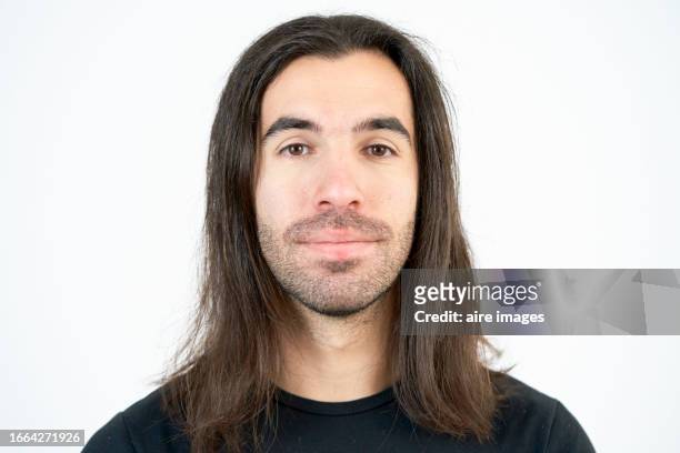 close-up portrait of a man's face with long hair smiling looking towards the camera, front view with white background - long nose foto e immagini stock