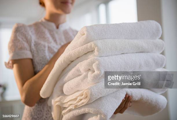 woman holding stack of white towels - towel imagens e fotografias de stock