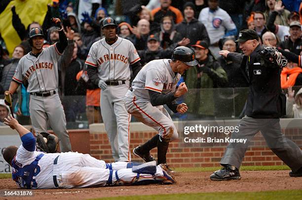 Hunter Pence of the San Francisco Giants reacts after scoring past catcher Welington Castillo of the Chicago Cubs on a double hit by Brandon Belt of...
