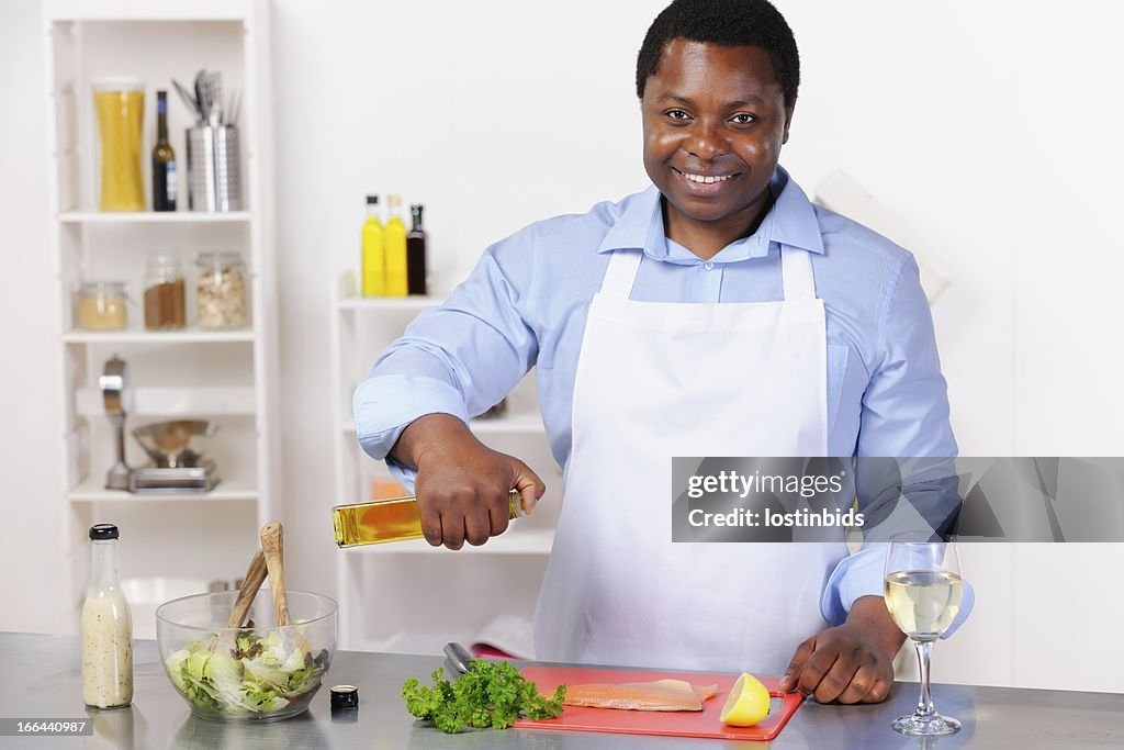 African American Mann Vorbereitung Filleted Fisch In einer regionalen Küche