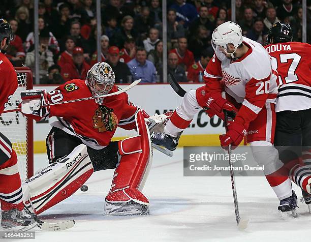 Drew Miller of the Detroit Red Wings attempts a shot against Corey Crawford of the Chicago Blackhawks at the United Center on April 12, 2013 in...