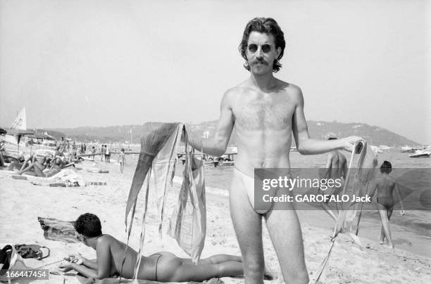 Topless Fashion In Saint-Tropez. En France, à Saint-Tropez, en juillet 1983, la mode vestimentaire sur la plage. Un homme, portant des lunettes de...