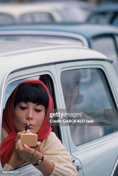 Motor Show 1963. En 1963, à l'occasion d'un salon automobile, dans un embouteillage, une femme portant un foulard rouge noué sur la tête, au volant...