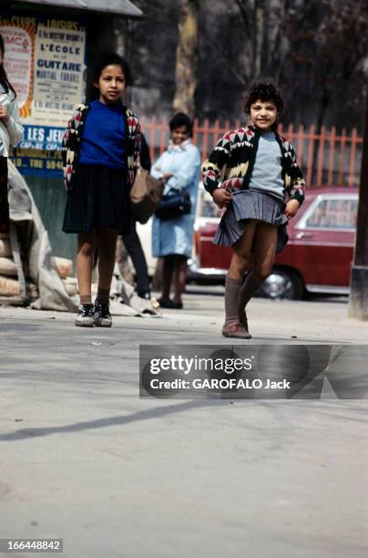 English Fashion Of Mini Skirts Invests Paris. Paris-avril 1964- La mode des mini jupes: une fillette relève sa jupe plissée pour mimer le mannequin...