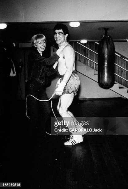 Rendezvous With Jacques Marty And His Wife. En 1966,dans une salle de boxe, le boxeur Jacques MARTY torse nu et sa femme sautant à la corde à sauter.