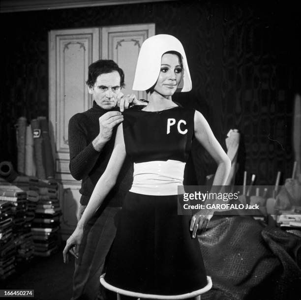 Fashion By Pierre Cardin. Le 22 janvier 1967, dans son atelier, le couturier Pierre CARDIN derrière une mannequin, ajuste l'¿¿paule d'une robe de sa...