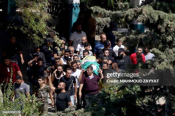 Mourners carry the body of a Fatah fighter who was killed during renewed fighting between members of the Fatah movement and hardline Islamist...