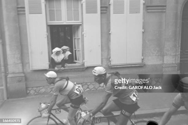 Tour De France. France, lors du Tour de France cycliste de juillet 1954, en Saintonge, deux bonnes soeurs en cornette à la fenêtre d'un maison...