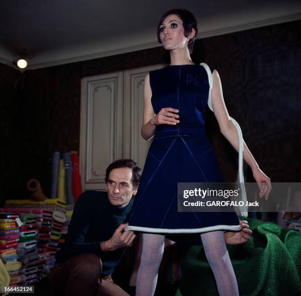 Fashion By Pierre Cardin. Le 22 janvier 1967, dans son atelier, le couturier Pierre CARDIN accroupi derrière un mannequin, réalise une robe de sa...