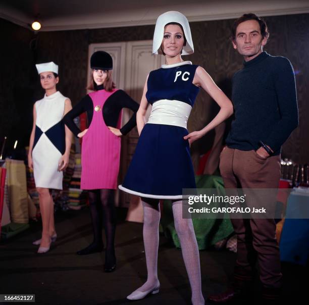 Fashion By Pierre Cardin. Le 22 janvier 1967, dans son atelier, le couturier Pierre CARDIN pose à côté de trois mannequins portant des robes sa...