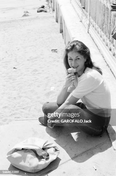 The 10Th Cannes Film Festival 1957. Le 10ème Festival de Cannes se déroule du 2 au 17 mai 1957 : une femme souriante mangeant une glace en bord de...