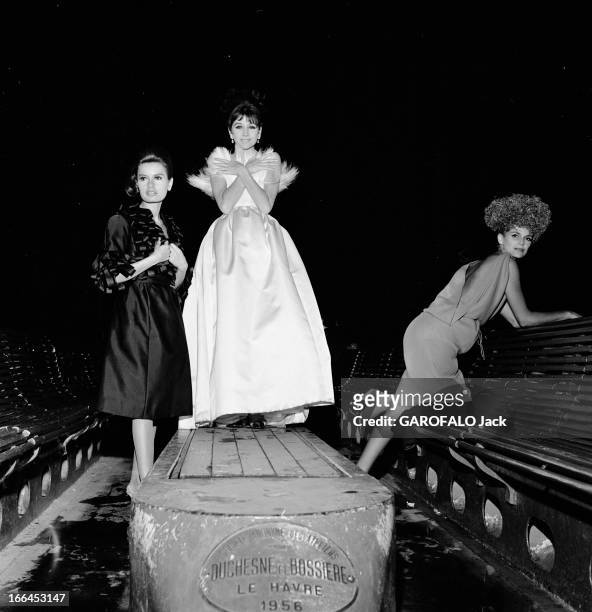 Fashion Presentation On The Seine. France, Paris, 23 aout 1962, présentation de mode sur un bateau mouche voguant sur la Seine. Ici la nuit trois...