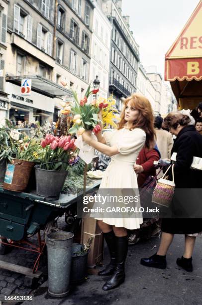 Rendezvous With Catherine Rouvel. Paris - mars 1969 - A l'occasion de son rôle dans 'Fanny', sur un marché, l'actrice Cathrine ROUVEL en robe blanche...