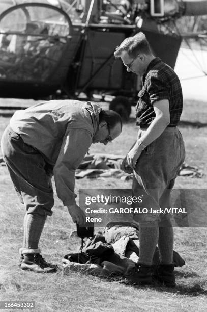 Henry And Vincendon. Le 21 mars 1957, deux hommes non identifiés devant l'hélicoptère l''Alouette', qui ramena les corps des alpinistes Jean...