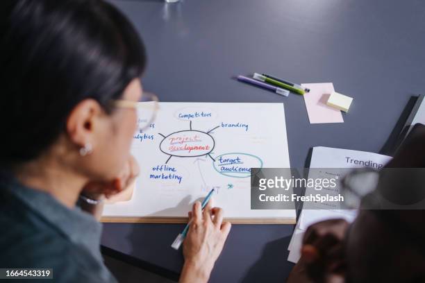 a from above view of two unrecognizable colleagues working together in the office - mind map stock pictures, royalty-free photos & images