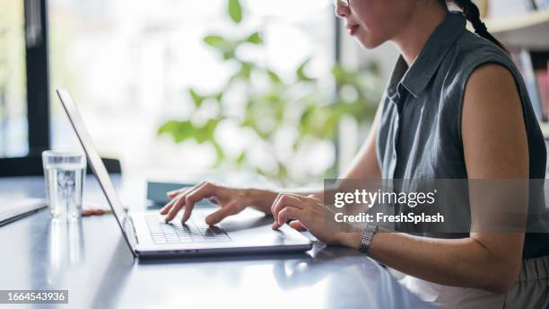 an unrecognizable beautiful asian businesswoman using her computer while working in the office - input device stock pictures, royalty-free photos & images