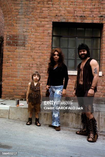Communities In California. En Californie, en janvier 1971, dans une rue, une femme au jean délavée, entourée d'un homme et d'un enfant portant des...