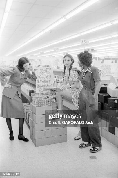 Communities In California. Etats-Unis, Californie, janvier 1971, ici dans chez un disquaire, 3 femmes discutent. Une employée en uniforme de travail...