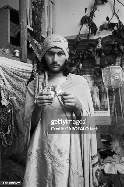 Communities In California. Etats-Unis, Californie, janvier 1971, ici dans un appartement où règne le désordre, un jeune homme barbu s'est enveloppé...