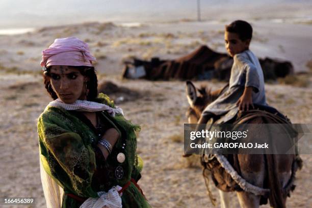 Algeria And Its Capital: Algiers. En novembre 1970, aux abords d'Alger, sur un terrain aride, une femme au visage tatoué en habit traditionnel, pose...