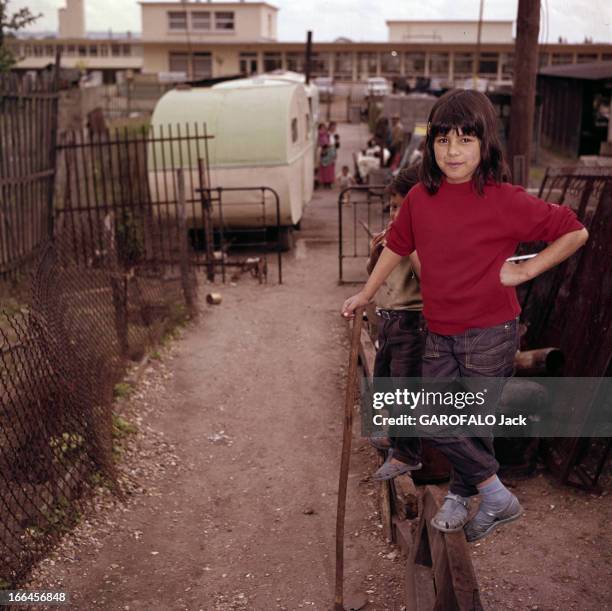 Rendezvous With Nina Demestre. Courbevoie- mai 1963- Portrait de Nina DEMESTRE, souriante, en polo rouge sur jeans, posant jambes croisées, appuyée...