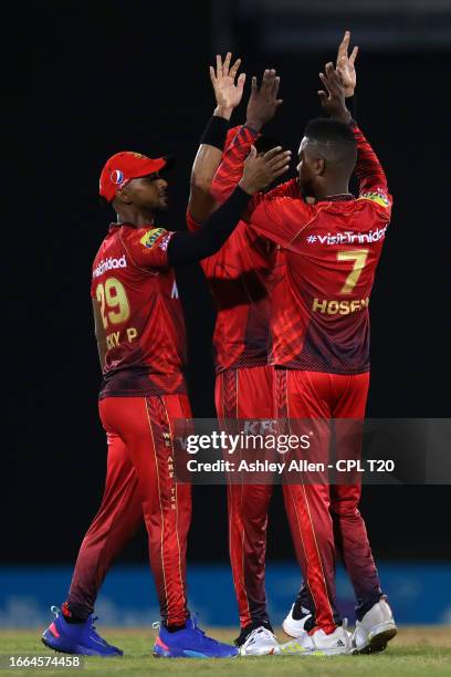 Akeal Hosein of Trinbago Knight Riders celebrates with teammates after getting the wicket of Rahkeem Cornwall of Barbados Royals during the Republic...