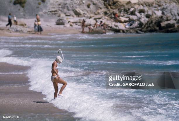Holidays In A Camping On The French Rivieira. Côte d'Azur- 1958- Vacances en camping en Méditerranée. Une jeune femme en bikini, bonnet, masque et...