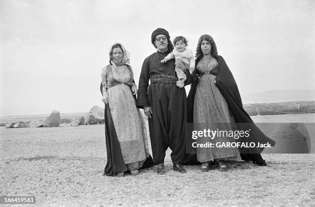 Iran. En Iran, en mai 1975, un couple en vêtement traditionnel des campagnes, avec leurs enfants, posant dans un champ aride.