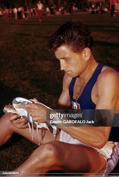 Michel Jazy At Belgrade European Athletics Championships In 1962. Belgrade - septembre 1962 - L'athlète Michel JAZY assis dans l'herbe en tenue de...