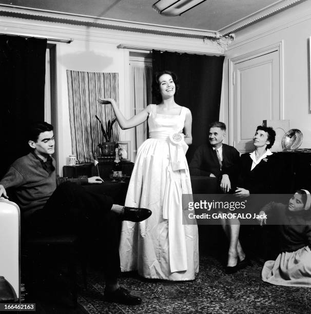Rendezvous With Claudine Auger. 16 octobre 1958, Claudine AUGER, Miss France 1958, pose avec une robe de soirée, en famille , dans un appartement.