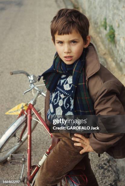 Rendezvous With Cecile Aubry And Her Son Sebastian . France- 1965- Portrait de SEBASTIEN, en blouson de cuir, écharpe et pull fantaisie, assis sur...