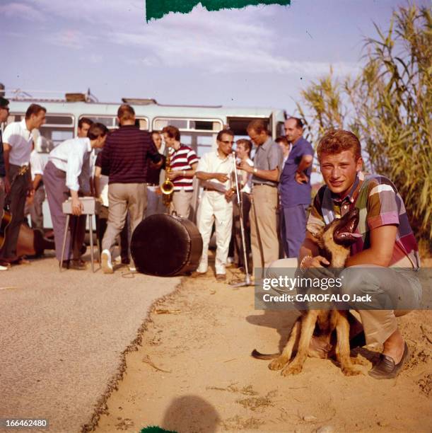 Rendezvous With Johnny Hallyday In Saint Tropez. Saint-Tropez - 1963 - Devant un groupe de personnes dont des musicien réunis devant un autocar, le...