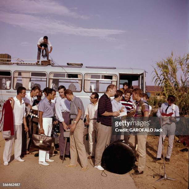 Rendezvous With Johnny Hallyday In Saint Tropez. Saint-Tropez - 1963 - Devant un groupe de personnes dont des musicien réunis devant un autocar, le...